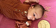 Mila participe au concours pour gagner de l'argent avec cette photo : baby, infant, child, lying_down, blanket, soft_toy, wooden_plaque, milestone, rust_colored_clothing, pink_background, cute, portrait, small_hands, face, head, buttoned_clothing, hair_clip, resting, indoors, peaceful