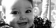 Mila participe au concours pour gagner de l'argent avec cette photo : baby, baby_toy, black_and_white, cheerful, child, closeup, clothing, cute, expression, face, flower_pattern, hand, happy, indoor, infant, person, playtime, portrait, smiling, young_child