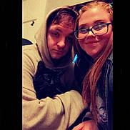 Jake is registered to the contest to win money with this photo: indoor, selfie, person, hoodie, glasses, cat, black_cat, face, smile, young_adult, casual_clothing, closeup, portrait, seated, warm_lighting, pet, animal, friendship, cozy, together