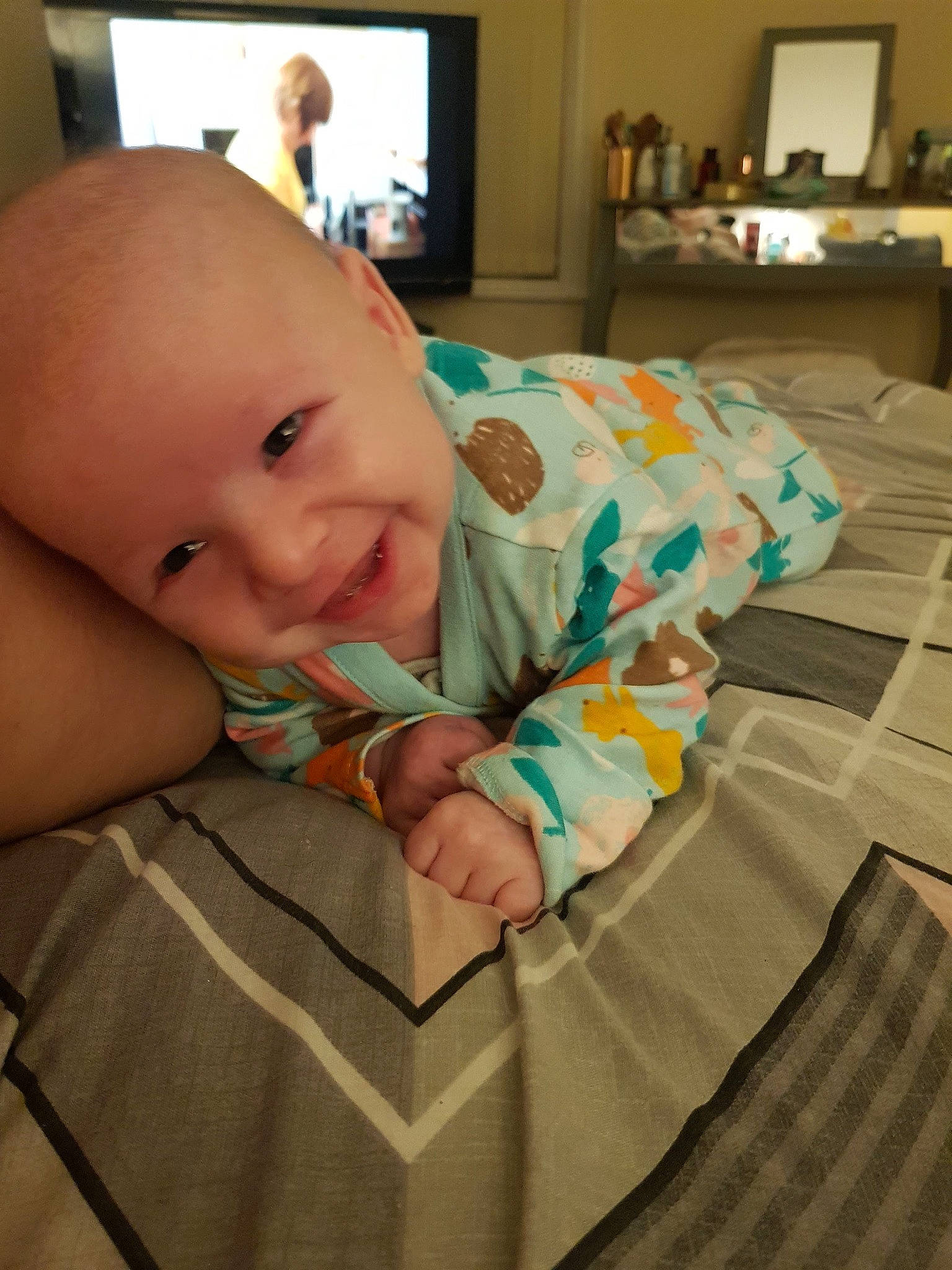 Leon is registered to the contest to win money with this photo: baby, baby_toddler_clothing, child, comfort, couch, finger, floor, flooring, hand, human_body, linens, mouth, nail, person, room, sitting, skin, smile, television, thumb