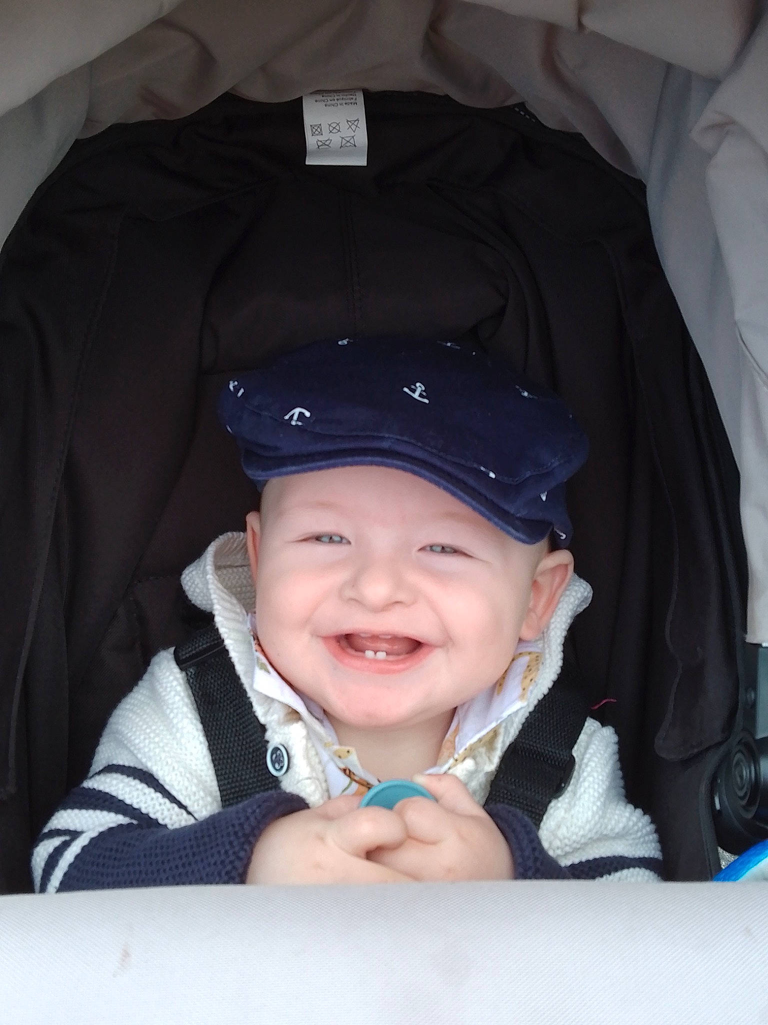 Leon is registered to the contest to win money with this photo: baby, baby_carriage, baby_laughing, baby_products, baby_toddler_clothing, cap, cheek, child, comfort, cool, electric_blue, fashion_accessory, flash_photography, fun, gesture, happy, headwear, joy, person, sleeve