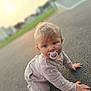 Lyana participe au concours pour gagner de l'argent avec cette photo : baby, pacifier, pajamas, crawling, outdoor, pavement, sunset, blurred_background, child, cute, infant, blue_eyes, soft_light, casual_clothing, small_hands, curly_hair, person, natural_light, skin, expression