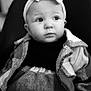 baby, infant, headband, bow, blanket, plaid, black_and_white, portrait, closeup, cute, child, face, eyes, clothing, sitting, young, person, indoors, warm, soft