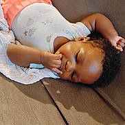 Ariyah joined the competition — help win amazing prizes! baby, infant, child, blanket, sleeping, lying_down, soft_texture, curly_hair, cute, peaceful, indoors, comfort, clothing, onesie, relaxing, skin, face, hand, fingers, resting
