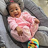 baby, bouncer, carpet, child, colorful_toy, face, furniture, hair_bow, happy, indoor, infant, joyful, living_room, pink_outfit, playtime, portrait, rocker, sitting, smiling, toy