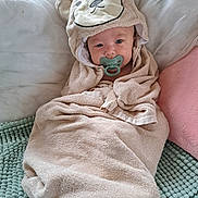 Jackson is registered to the contest to win money with this photo: baby, towel, pacifier, hood, bear_design, infant, wrapped, cushion, mat, soft_texture, lying_down, face, child, cute, indoors, blanket, comfort, resting, person, portrait