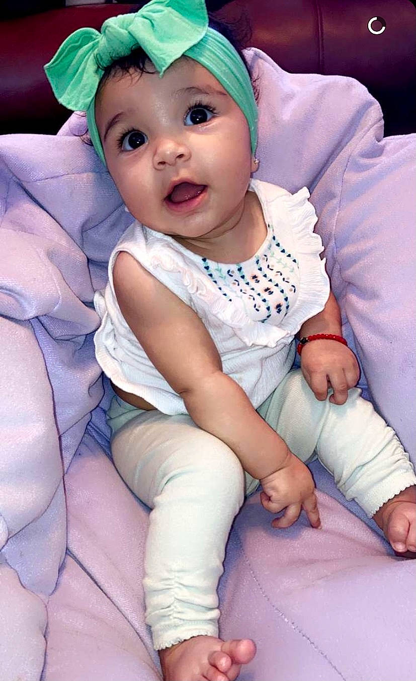 Myla is registered to the contest to win money with this photo: baby, baby_toddler_clothing, cap, child, eye, face, facial_expression, finger, fun, happy, headwear, knee, people, person, photograph, pink, purple, skin, sleeve, sock