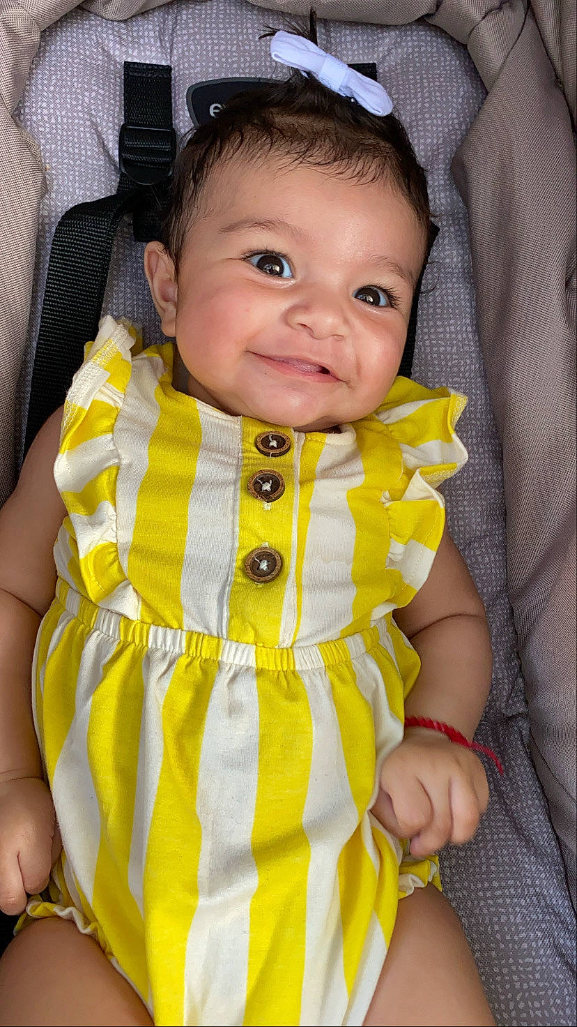 Myla is registered to the contest to win money with this photo: baby, baby_products, baby_safety, baby_toddler_clothing, cheek, chin, collar, comfort, eye, finger, fun, happy, iris, joy, linens, pattern, person, skin, sleeve, smile