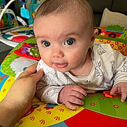 Sadie joined the competition — help win amazing prizes! baby, child, clothing, colorful, comfort, couch, curious_expression, cute, face, hand, head, home, indoor, infant, person, play_mat, smiling, soft, toys, young