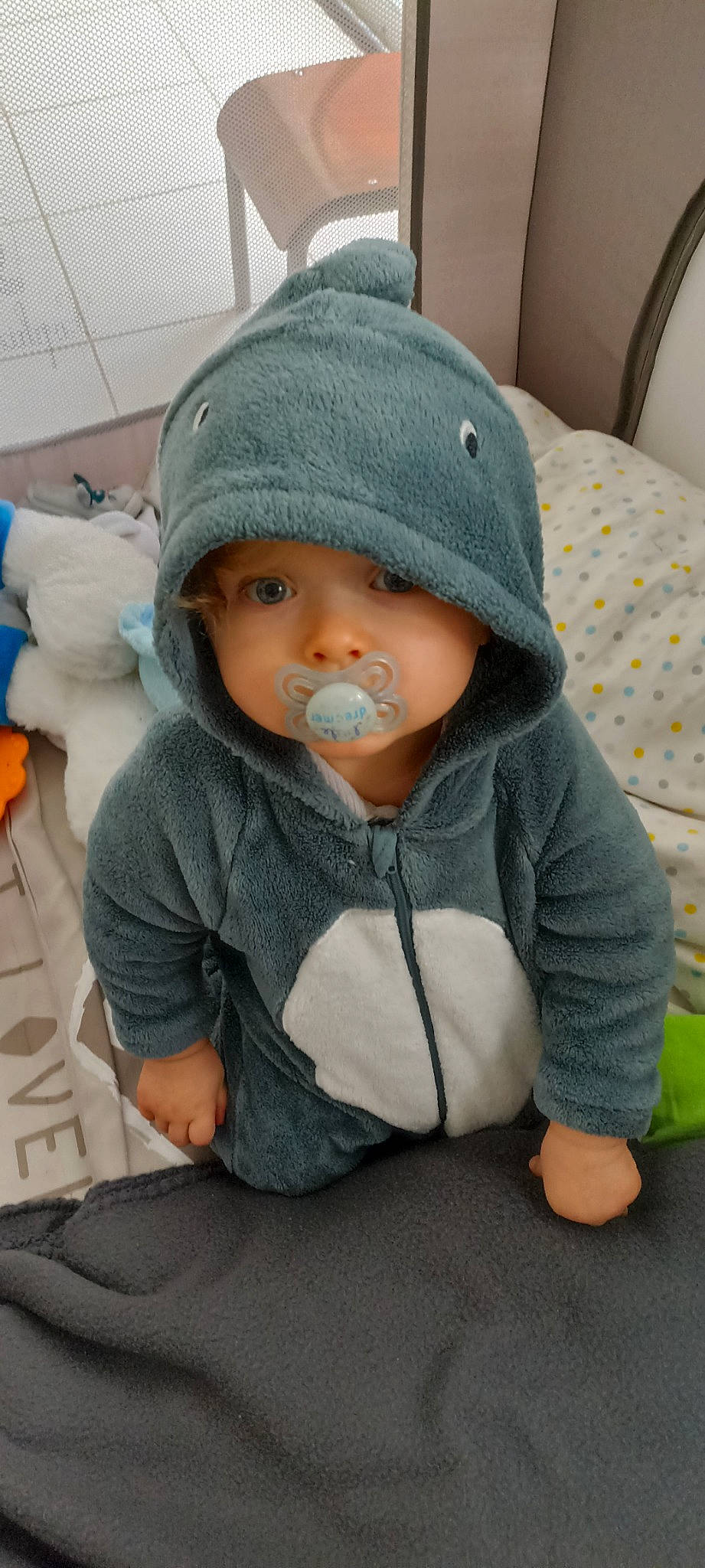 Lenny a rejoint le concours — aidez-le/la à gagner de superbes lots ! baby, baby_products, baby_toddler_clothing, beanie, cap, cheek, child, comfort, face, grey, headwear, hood, hoodie, jacket, knit_cap, outerwear, person, sitting, sleeve, toddler