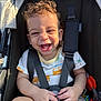 Jayden joined the competition — help win amazing prizes! toddler, child, stroller, smiling, laughing, curly_hair, harness, white_shirt, orange_print, shorts, toy, sunlight, outdoor, happy, baby, seat, hands, face, person, closeup