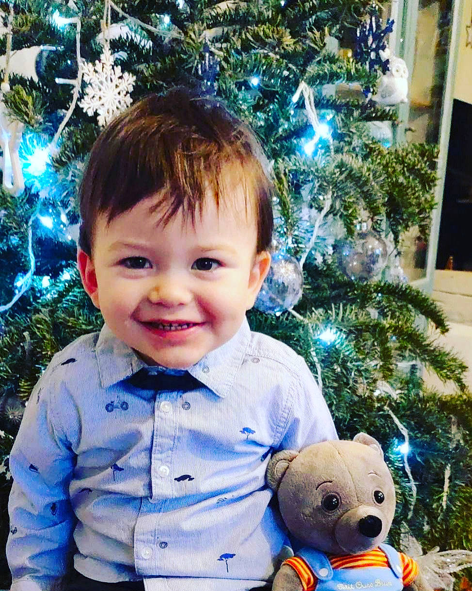 Marceau a rejoint le concours — aidez-le/la à gagner de superbes lots ! baby, baby_toddler_clothing, blue, christmas_decoration, christmas_ornament, christmas_tree, facial_expression, green, happy, head, holiday_ornament, joy, light, organ, people_in_nature, person, photograph, smile, standing, toddler