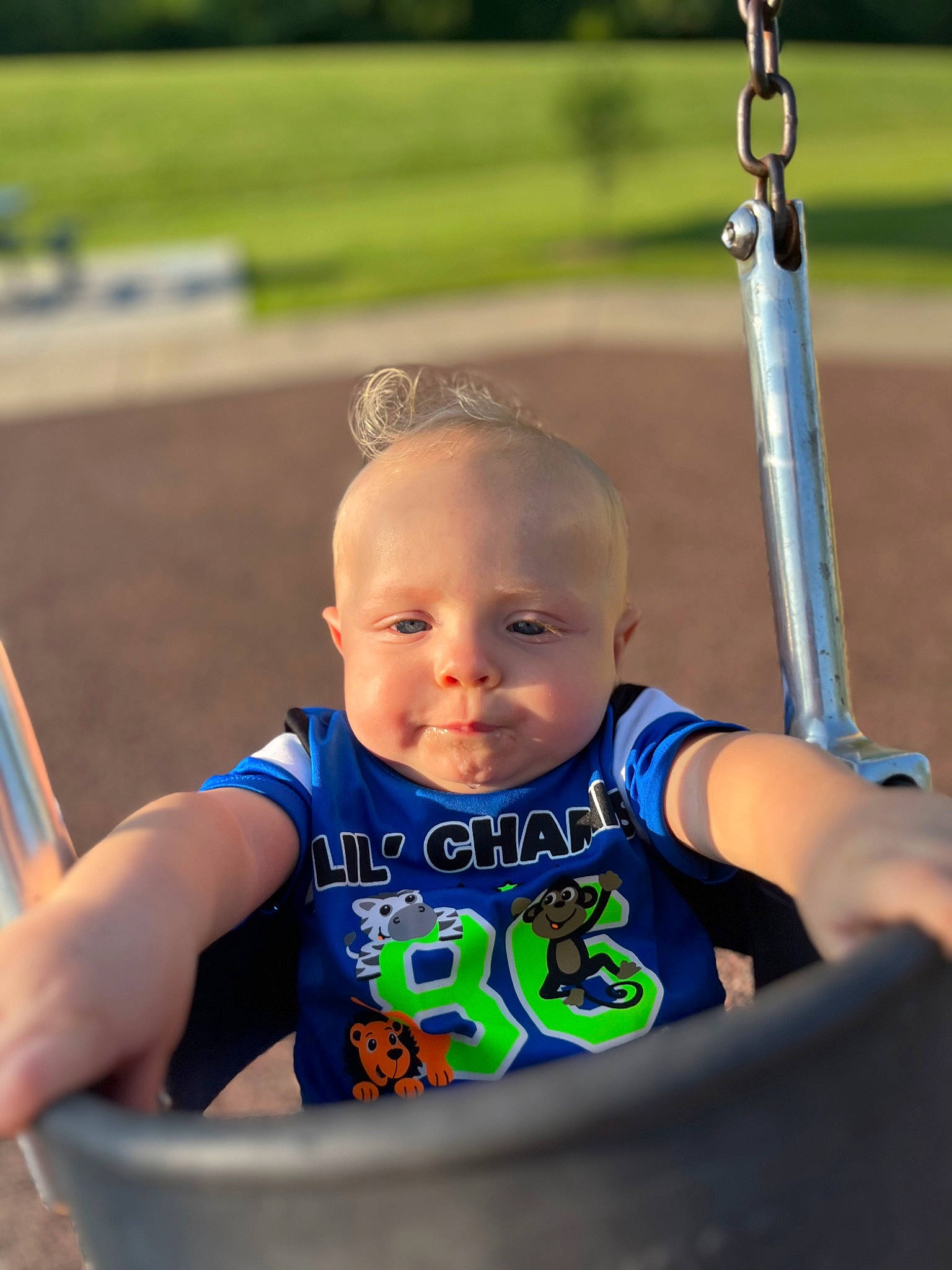 River is registered to the contest to win money with this photo: arm, eye, facial_expression, fun, grass, hair, hand, happy, head, human_body, leisure, person, photograph, product, recreation, skin, smile, swing, toddler, white