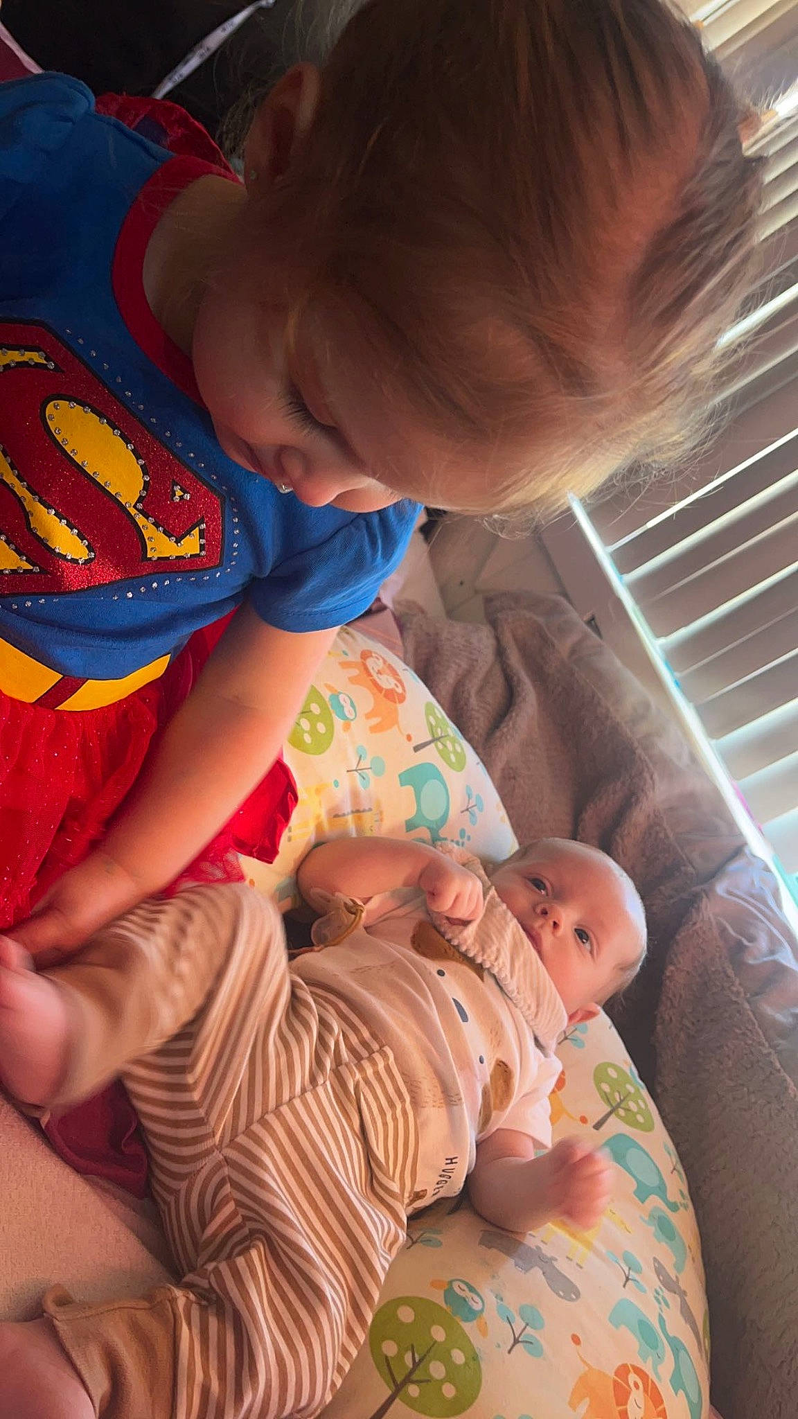 River is registered to the contest to win money with this photo: arm, baby, baby_products, cheek, child, comfort, facial_expression, finger, fun, happy, human_body, interaction, lap, leg, mouth, person, room, sitting, skin, toddler