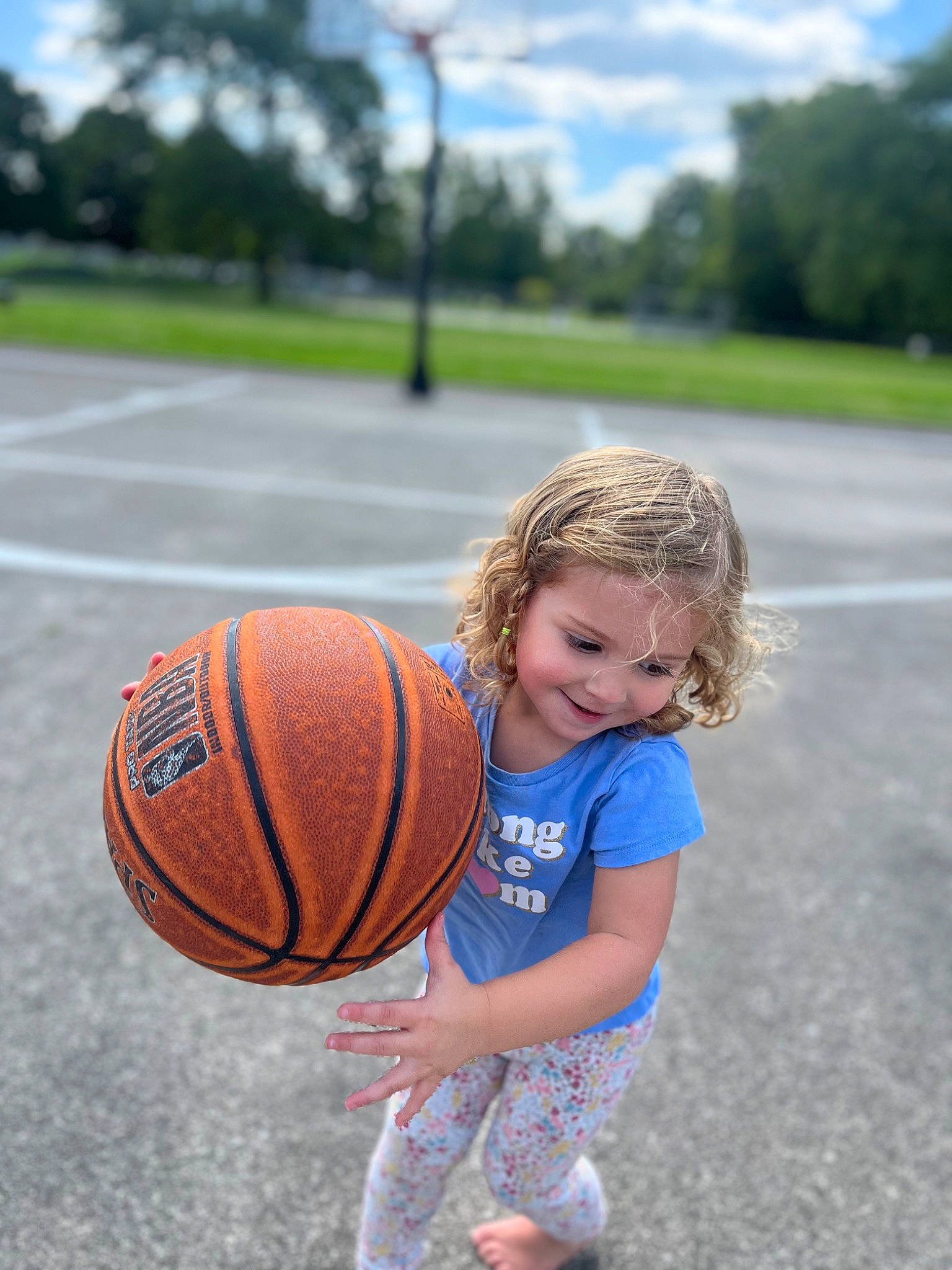 Adalyn is registered to the contest to win money with this photo: ball, ball_game, basketball, cloud, grass, happy, joy, leisure, people_in_nature, person, player, playing_sports, sky, smile, sports, sports_equipment, sports_toy, streetball, team_sport, toddler
