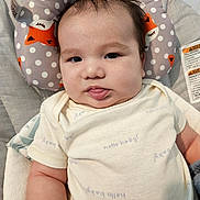 Lloyd joined the competition — help win amazing prizes! baby, infant, child, portrait, face, tongue_out, looking_at_camera, awake, smiling, chubby_cheeks, dark_hair, onesie, clothing, cushion, baby_seat, fox_pattern, polka_dots, indoor, close_up, safety_label