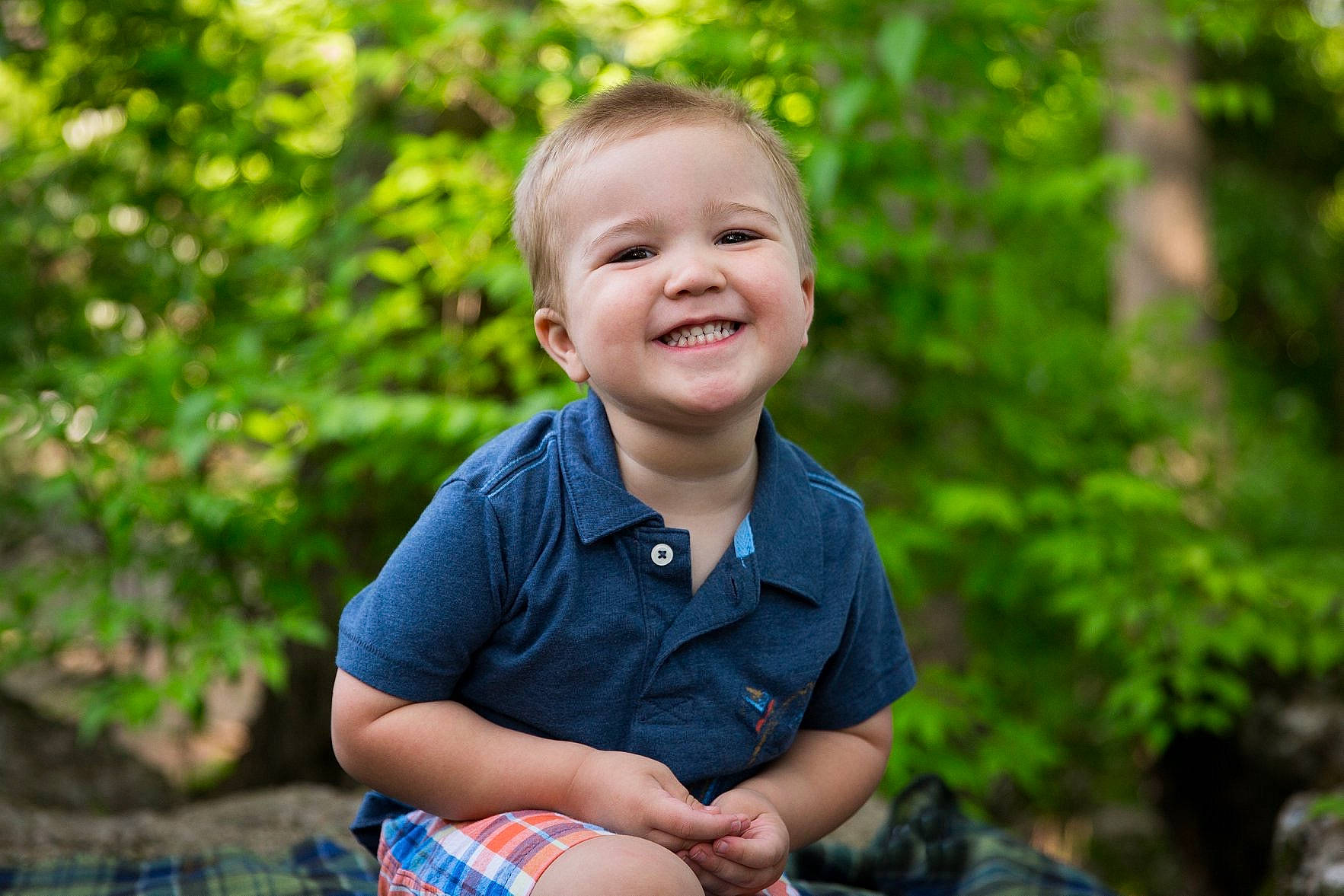 Clark is registered to the contest to win money with this photo: blue, child, eye, facial_expression, grass, green, happy, joy, laugh, male, people, people_in_nature, person, photograph, photography, portrait, portrait_photography, sitting, smile, summer