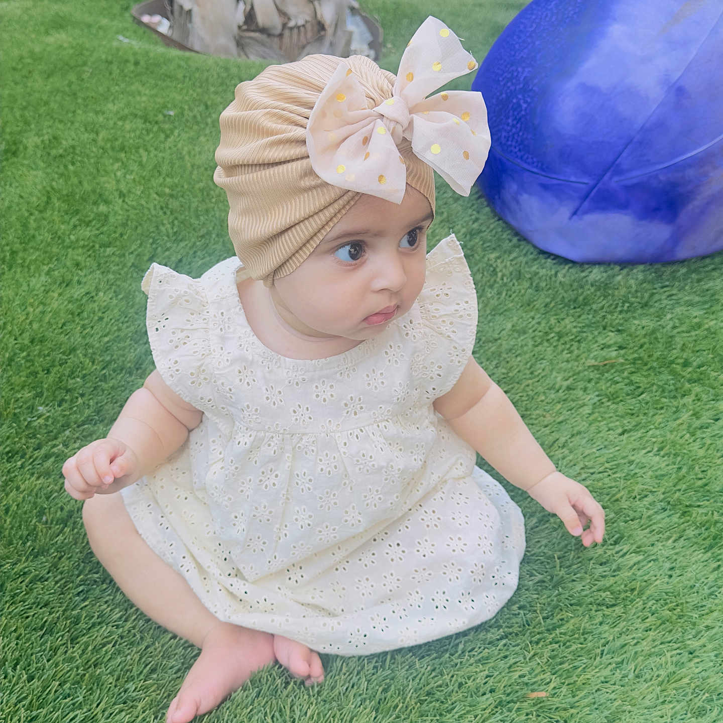 Iman Ali Khan joined the competition — help win amazing prizes! baby, barefoot, bow, child, curious, cute, daylight, dress, grass, greenery, headwear, infant, outdoor, person, playground, purple_ball, sitting, toy, turban, yellow_car