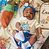 baby, blanket, bunny_ears, carrot, celebration, child, clothing, confetti, cute, decorations, easter, festive, happy, holiday, indoors, portrait, smile, sock, toddler, toy