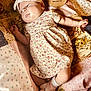 baby, infant, one_month, headband, bow, floral_dress, socks, quilt, patterned_blanket, lying_down, cute, newborn, soft_lighting, indoors, child, portrait, sleepwear, resting, small_hands, peaceful
