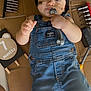 baby, child, denim_overalls, headband, wrench, tools, cardboard, face_paint, 7_months_sign, cute, smiling, indoors, hand, foot, light_skin, playful, portrait, infant, clothing, toy_tool