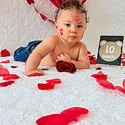 Lucas joined the competition — help win amazing prizes! baby, celebration, child, crawling, cute, decorations, face, heart_balloon, heart_garland, holiday, indoor, infant, jeans, kiss_marks, milestone_sign, portrait, red_rose, rose_petals, skin, white_blanket