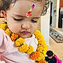 Maanasbi joined the competition — help win amazing prizes! child, toddler, face_paint, marigold_garland, yellow_flowers, pink_dress, indoor, curly_hair, portrait, young_child, close_up, decorative, flower_necklace, colorful, paint, expression, person, cute, celebration, background_child