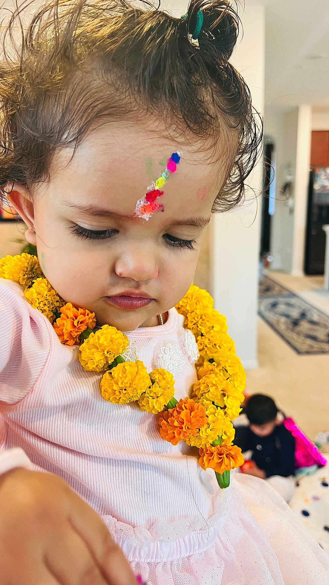 Maanasbi joined the competition — help win amazing prizes! child, toddler, face_paint, marigold_garland, yellow_flowers, pink_dress, indoor, curly_hair, portrait, young_child, close_up, decorative, flower_necklace, colorful, paint, expression, person, cute, celebration, background_child