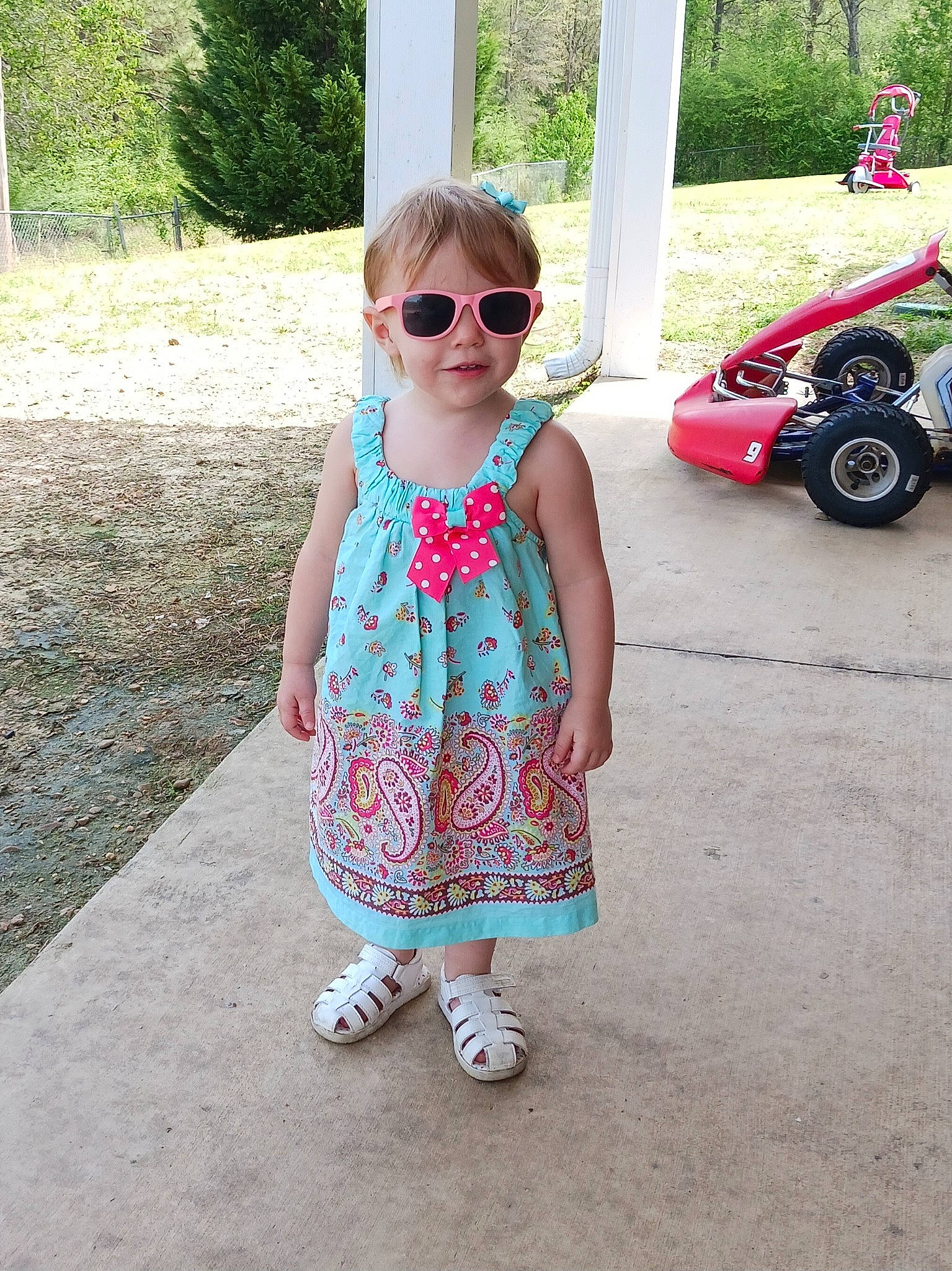 Cheyenne joined the competition — help win amazing prizes! baby_toddler_clothing, car, cool, dress, eyewear, glasses, goggles, grass, leisure, person, pink, plant, sleeve, smile, summer, sunglasses, tire, toddler, tree, vehicle