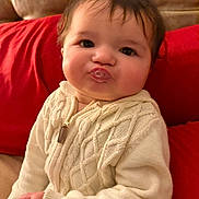 Jadiel is registered to the contest to win money with this photo: baby, child, couch, cute, expression, face, hand, indoors, knitwear, plush, portrait, pucker, red_cushion, seated, skin, smile, soft_lighting, sweater, warm, young_child