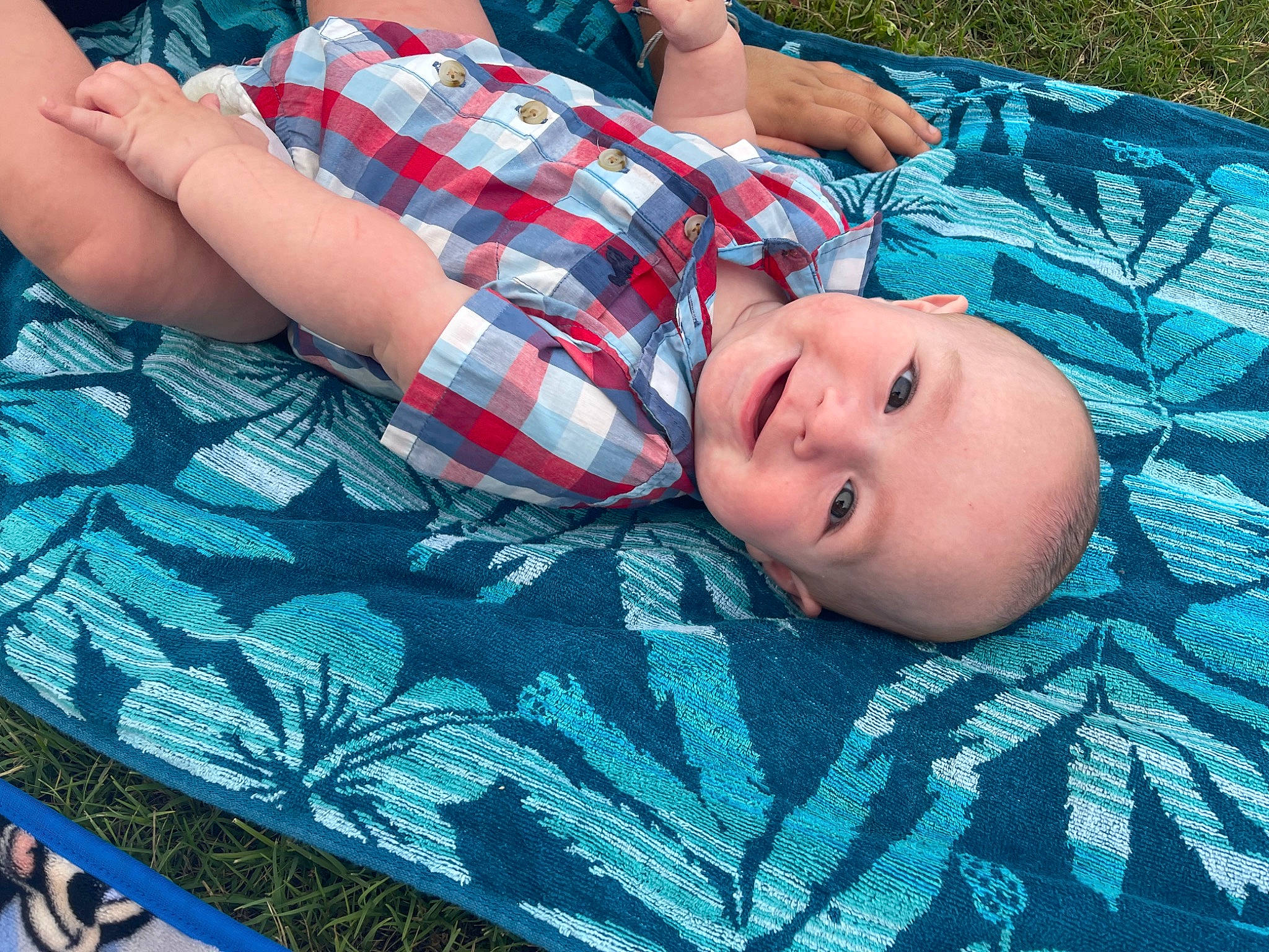 Reece is registered to the contest to win money with this photo: baby, baby_toddler_clothing, bedding, blue, child, comfort, electric_blue, fun, grass, green, joy, leisure, linens, pattern, person, plaid, smile, tartan, textile, toddler