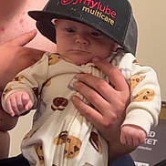 Adam is registered to the contest to win money with this photo: adult_hand, baby, cap, child, clothing, cookies, cozy, cute, expressionless, face, hand, hat, holding, indoor, infant, jiffy_lube, milk_carton, pajamas, person, portrait