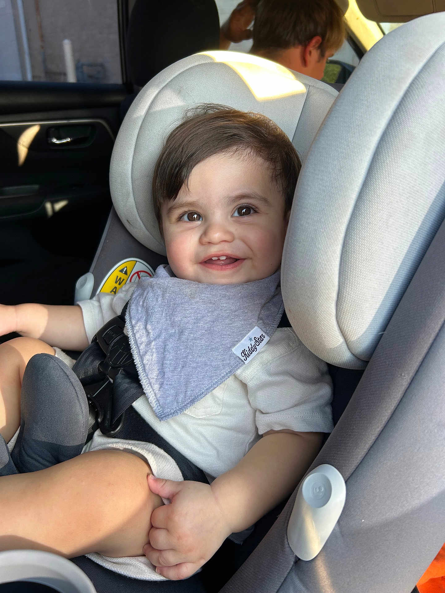 Carmelo is registered to the contest to win money with this photo: toddler, child, car_seat, smile, baby, seatbelt, clothing, person, face, indoor, car, sitting, happy, hair, head, light, window, seat, adult, safety