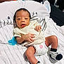 Coa is registered to the contest to win money with this photo: baby, infant, diaper, socks, pacifier, blanket, striped, clothing, cute, face, hands, legs, lying_down, indoors, soft, comfort, newborn, expression, young_child, resting