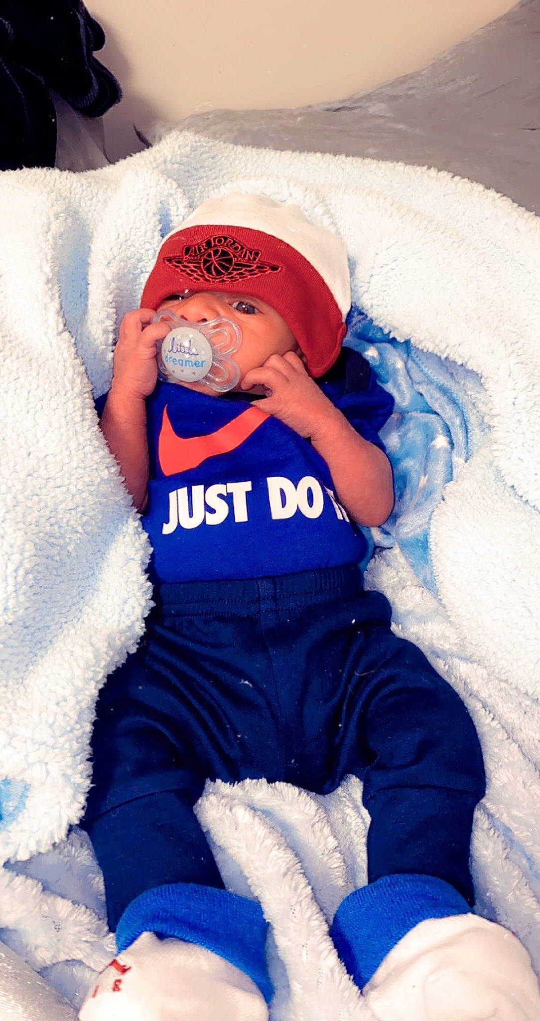 Kamari is registered to the contest to win money with this photo: azure, baby, baby_products, baby_toddler_clothing, blue, cap, child, clothing, comfort, electric_blue, happy, hat, human_body, leg, person, personal_protective_equipment, sleeve, t_shirt, textile, thigh