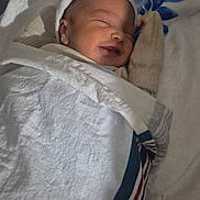 Angel is registered to the contest to win money with this photo: newborn, baby, sleeping, smiling, blanket, white, cap, mittens, cozy, resting, infant, portrait, soft, face, child, cute, bed, fabric, peaceful, wrapped