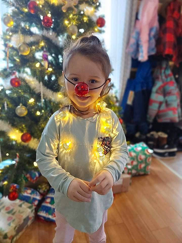 Léonie participe au concours pour gagner de l'argent avec cette photo : baby_toddler_clothing, child, christmas_decoration, christmas_ornament, christmas_tree, event, eyewear, fashion_design, flooring, fun, happy, holiday, holiday_ornament, ornament, party_supply, person, smile, standing, toddler, tradition