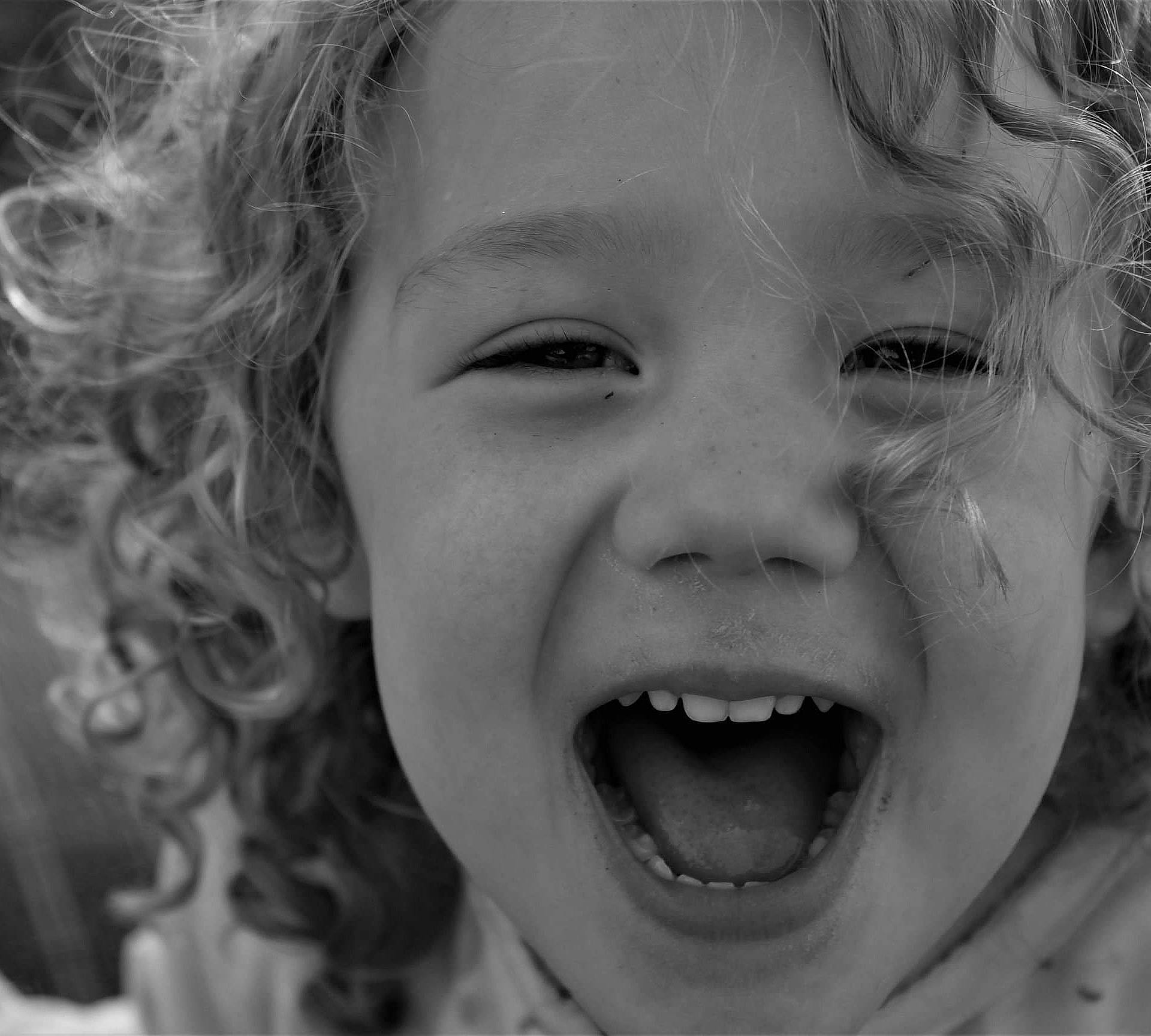 Karly is registered to the contest to win money with this photo: black_and_white, cheek, child, chin, close_up, eye, face, facial_expression, fun, happy, head, joy, laugh, monochrome, mouth, nose, organ, person, photograph, skin