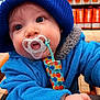 William joined the competition — help win amazing prizes! baby, blue_jacket, child, close_up, colorful, cute, expression, face, furniture, hand, high_chair, indoor, infant, knit_hat, pacifier, person, polka_dot, sitting, warm_clothing, winter_wear
