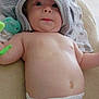 baby, infant, diaper, towel, toy, cute, child, skin, lying_down, wide_eyes, expression, indoors, blanket, soft, chubby, face, headwear, curious, paciifier, baby_bottle