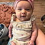 Emersyn is registered to the contest to win money with this photo: baby, child, infant, pink_bow, headband, floral_outfit, smiling, sitting, person, indoor, wooden_floor, blanket, hand, cute, portrait, young_child, clothing, happy, face, home