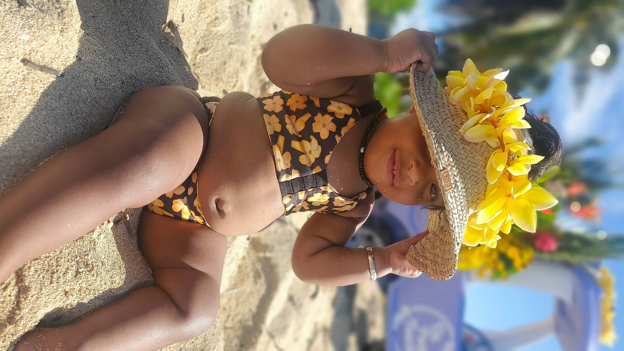 Kaiyah is registered to the contest to win money with this photo: abdomen, brassiere, child, event, flower, fun, happy, hat, headgear, headwear, human_leg, leg, leisure, people_in_nature, person, shorts, sun_hat, sunglasses, thigh, toddler