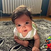 Havana joined the competition — help win amazing prizes! baby, infant, child, cute, face, eyes, hair, rug, floor, toy, home, indoor, crawling, clothing, white_shirt, green_overalls, curious, smiling, closeup, portrait