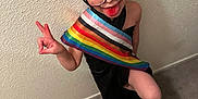 Glenna joined the competition — help win amazing prizes! child, glasses, tongue, peace_sign, pride_flag, short_hair, black_cloth, carpet, wall, playful, indoor, person, portrait, happy, expression, standing, colorful, cute, fun, eyes