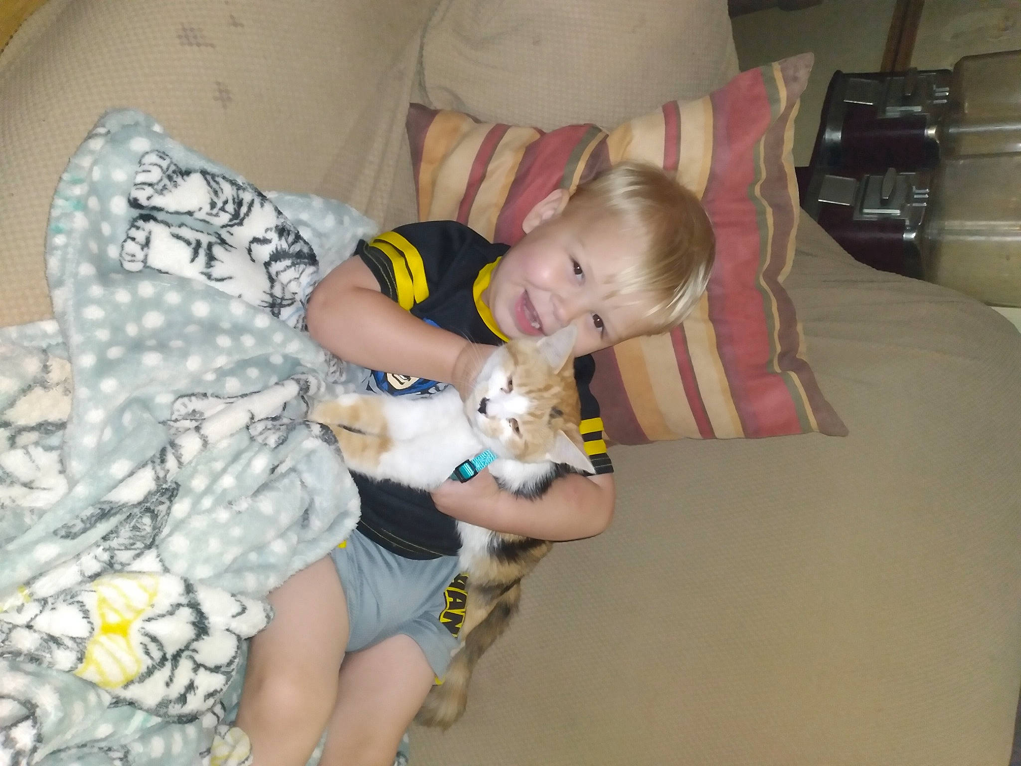 Keagan is registered to the contest to win money with this photo: baby, baby_products, baby_toddler_clothing, camouflage, child, comfort, facial_expression, flooring, fun, hairstyle, human_leg, knee, lap, leg, military_camouflage, pattern, person, room, sitting, thigh