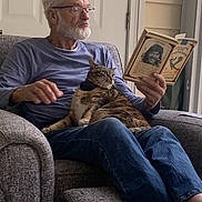 Babyboo joined the competition — help win amazing prizes! blue_shirt, book, calico_cat, cat_collar, comfort, cozy, domestic, elderly_man, furniture, glasses, gray_recliner, home, indoor, jeans, leisure, pet, reading, relaxation, seated, white_beard