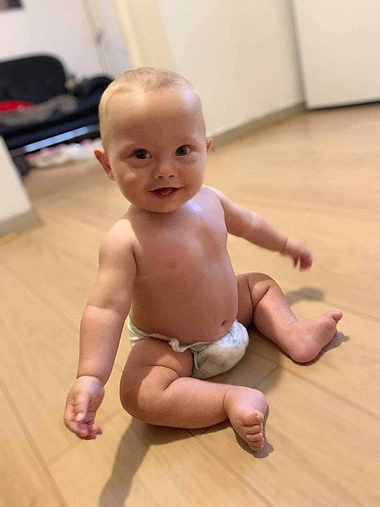Melvin participe au concours pour gagner de l'argent avec cette photo : abdomen, baby, cheek, chest, finger, floor, flooring, hardwood, human_leg, joint, knee, person, shoulder, skin, smile, stomach, thigh, thumb, toddler, trunk
