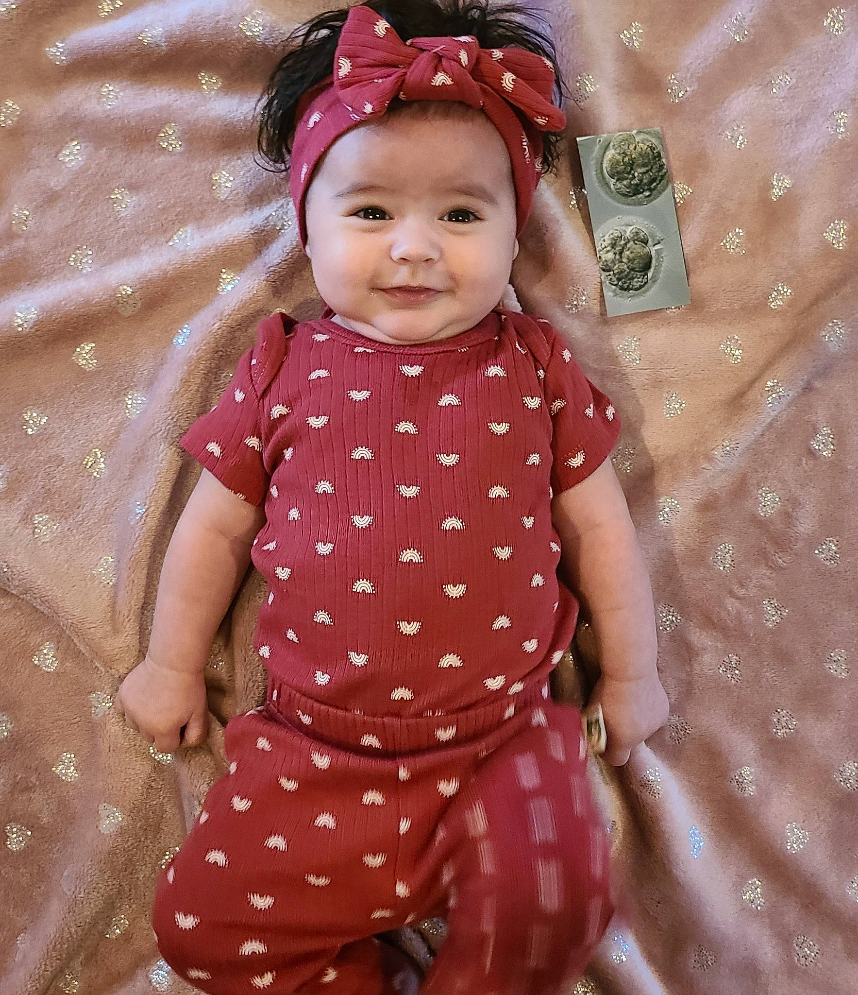 Alyza is registered to the contest to win money with this photo: baby, baby_toddler_clothing, child, doll, dress, face, facial_expression, happy, head, headwear, joy, magenta, pattern, person, pink, purple, skin, sleeve, smile, standing