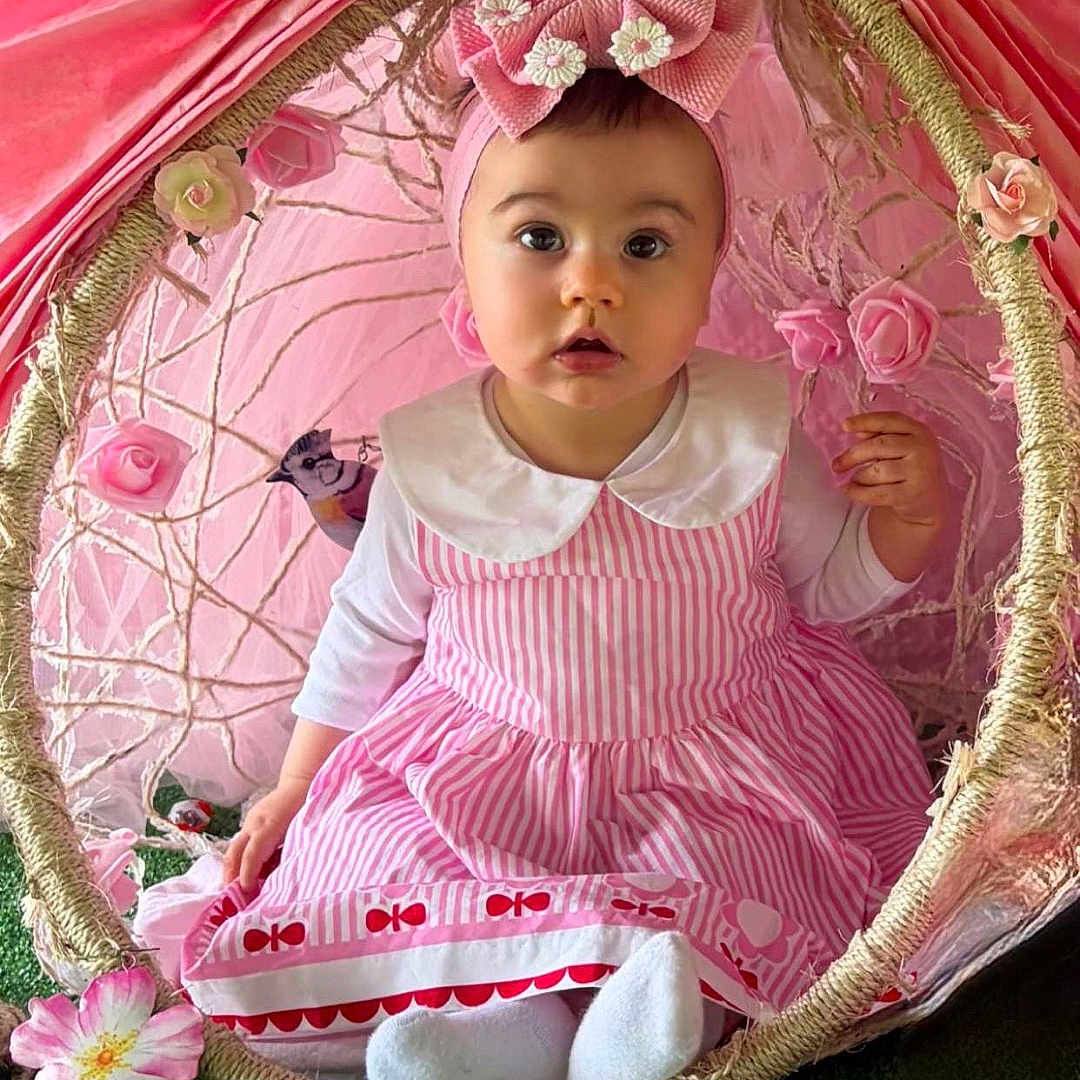 Soa a rejoint le concours — aidez-le/la à gagner de superbes lots ! adorable, baby, bird, bow, canopy, child, colorful, curious, cute, decor, face, flower, grass, headband, indoor, pink_dress, playful, portrait, seated, young_child