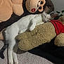 cat, sleeping, plush_toy, monkey_toy, teddy_bear, red_bow, red_shirt, indoor, cozy, relaxed, soft_texture, white_cat, tabby_cat, pet, cuddly, nap, feline, stuffed_animal, animal, resting